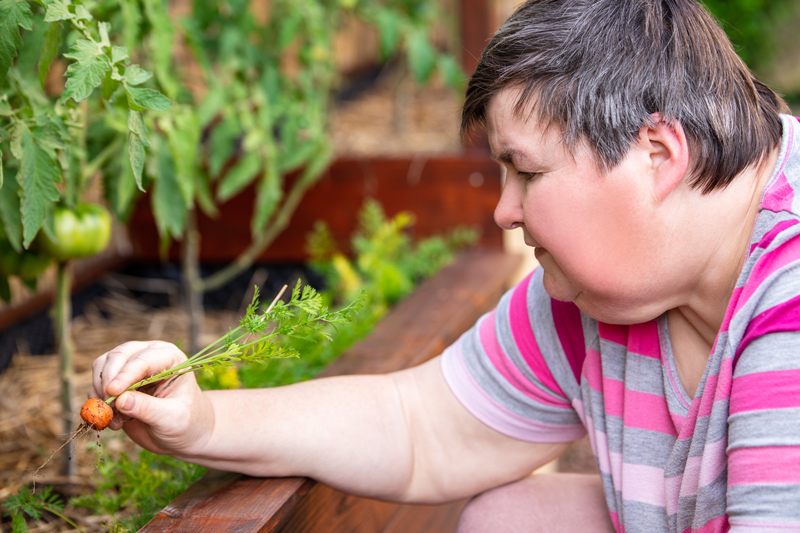 Girl with Down Syndrome holding a spoon - eating