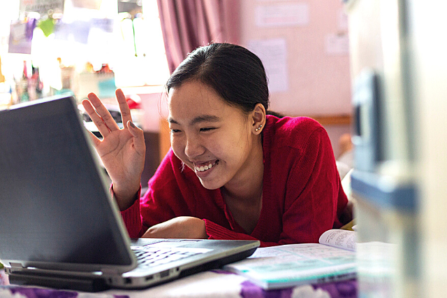 Girl with a disability looking at laptop