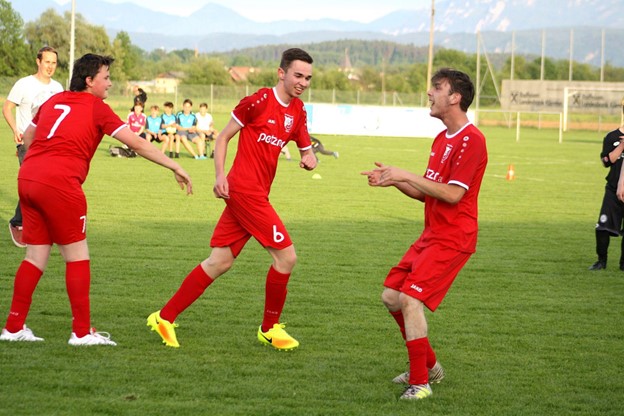 Young adults with disabilities in red uniforms with yellow shoes and red knee high socks on a soccer field