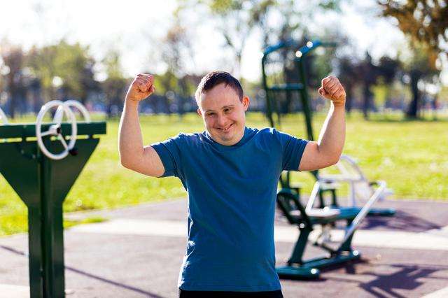 Young Adult with Down Syndrome with arms flexed