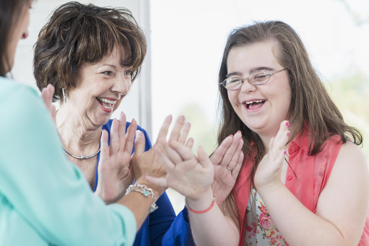 Down syndrome girl with family playing games Down syndrome girl with family playing games