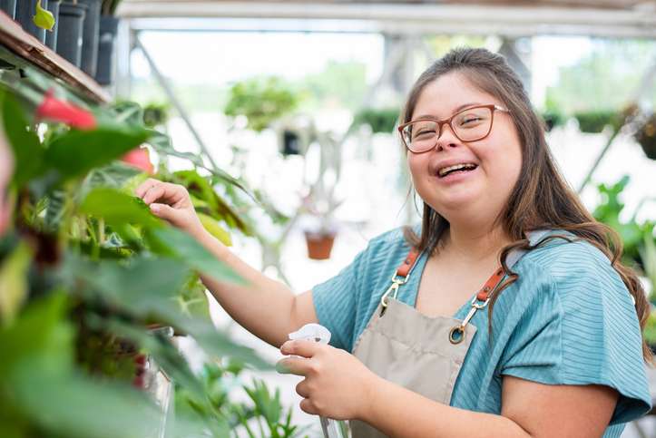 Social inclusion - woman with down syndrome working in small business Disability Advocacy group meeting