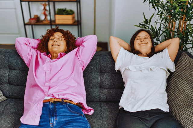 Family Caegiver and Young woman with down syndrome relaxing on a couch