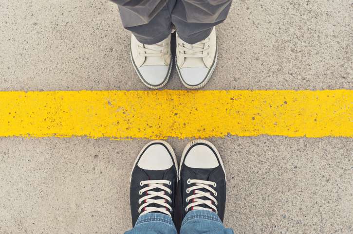 Sneakers from above. Yellow line with a pair of feet on each side facing each other