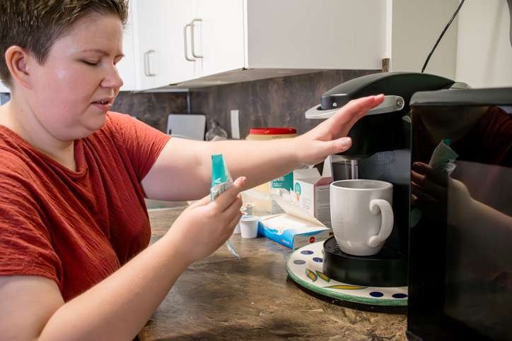 Woman in kitchen in her morning coffee routine