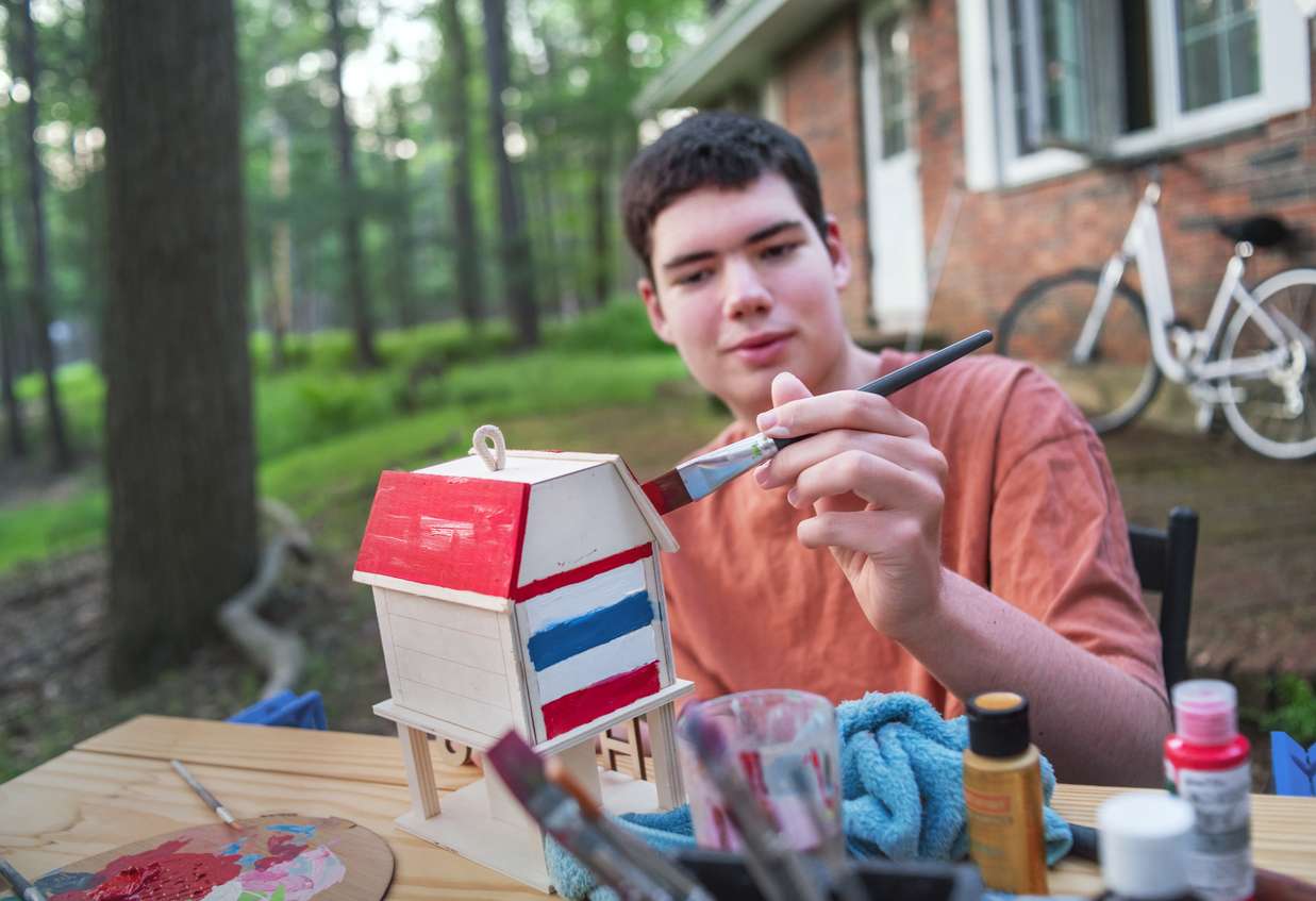 Young Man with Autism Painting outside his home